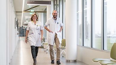 Oncoloog Rob van den Brom en verpleegkundig specialist Oncologie, Renate Leeuwis-de Vries lopen door de polikliniek in het Ommelander Ziekenhuis Groningen. 