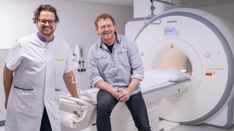 Mattia Valente, cardioloog, en Mark van den Heuvel, hoofd Medische Beeldvorming, staan bij een MRI-scan apparaat.