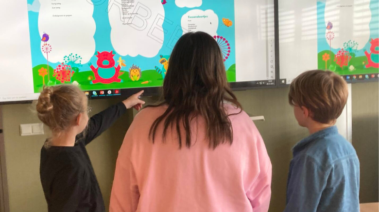 Drie leden van de Kinderadviesraad voor een scherm, kijkend naar het kindermenu