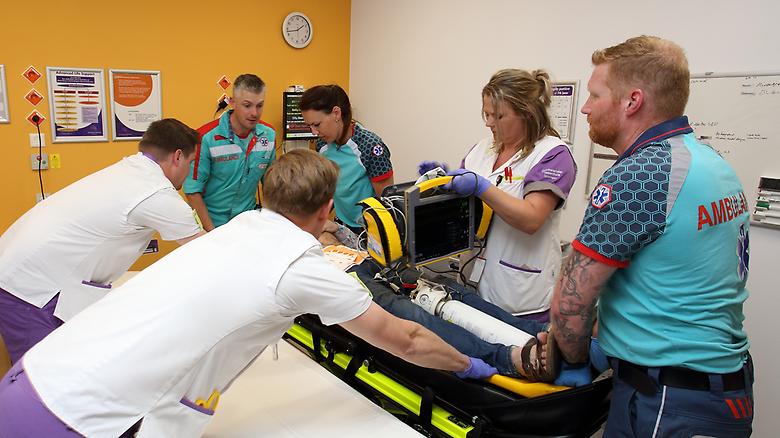 Ambulance medewerkers oefenen hulphandelingen op simulatiepop