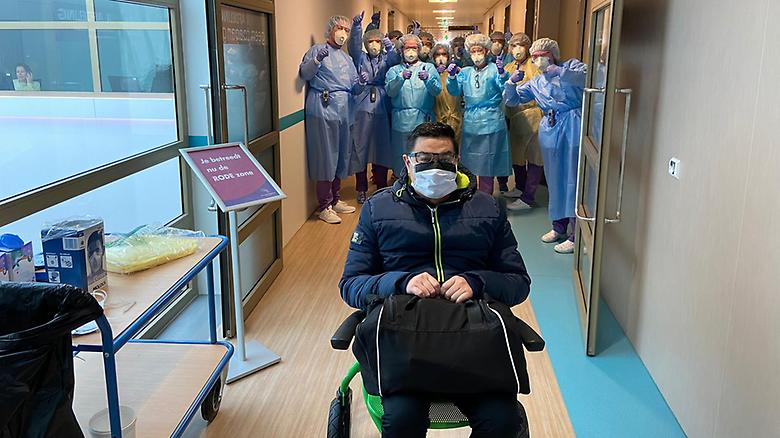  Ex corona-patient wordt uitgezwaaid door zorgverleners in beschermende pakken van het Ommelander Ziekenhuis Groningen’
